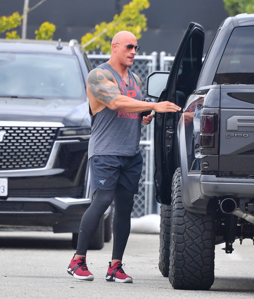 Dwayne Johnson getting into his Ford F-150, The Rock is the world's highest-paid actor that owns a cheap car