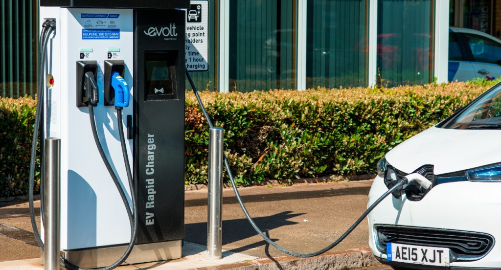 A white electric car plugged into Evolt charge point in Cambridge, England, UK.