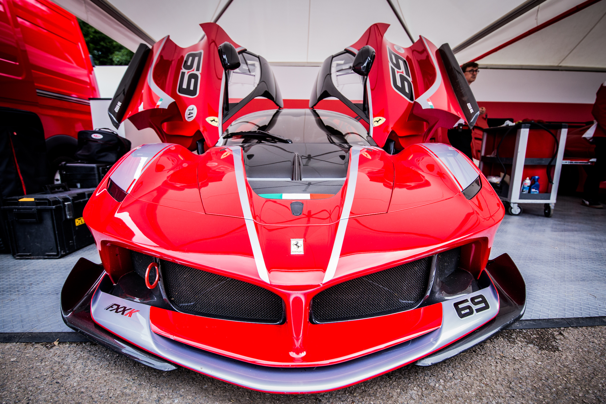 A red Ferrari FXX-K, one of the top 5 most expensive Ferraris, sits in the paddock awaiting its driver and passenger to tackle the Goodwood Hillclimb in June 2016