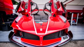 A red Ferrari FXX-K, one of the top 5 most expensive Ferraris, sits in the paddock awaiting its driver and passenger to tackle the Goodwood Hillclimb in June 2016