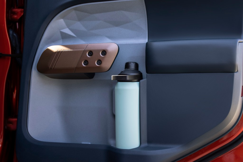The interior passenger door of the Ford Maverick with a water bottle in the door pocket