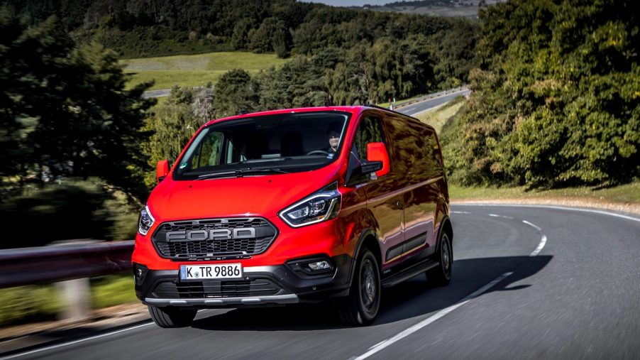 new Ford Nugget Plus Trail camper van in red driving down the road
