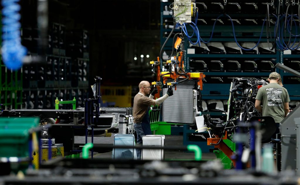 Autoworkers assemble the chassis of full-size pickup trucks at the General Motors plant in Flint, Michigan, in 2019