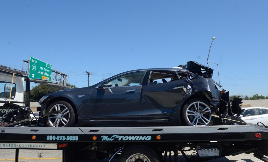 A crashed Tesla sits on a flatbed