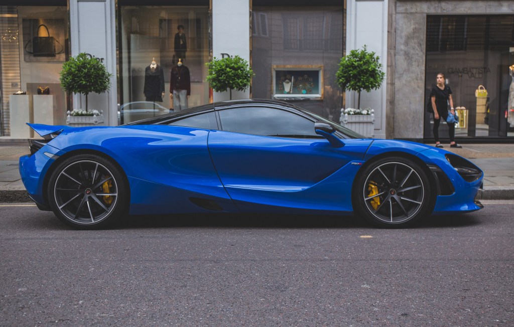 A blue Mclaren 720s on a streetside in London