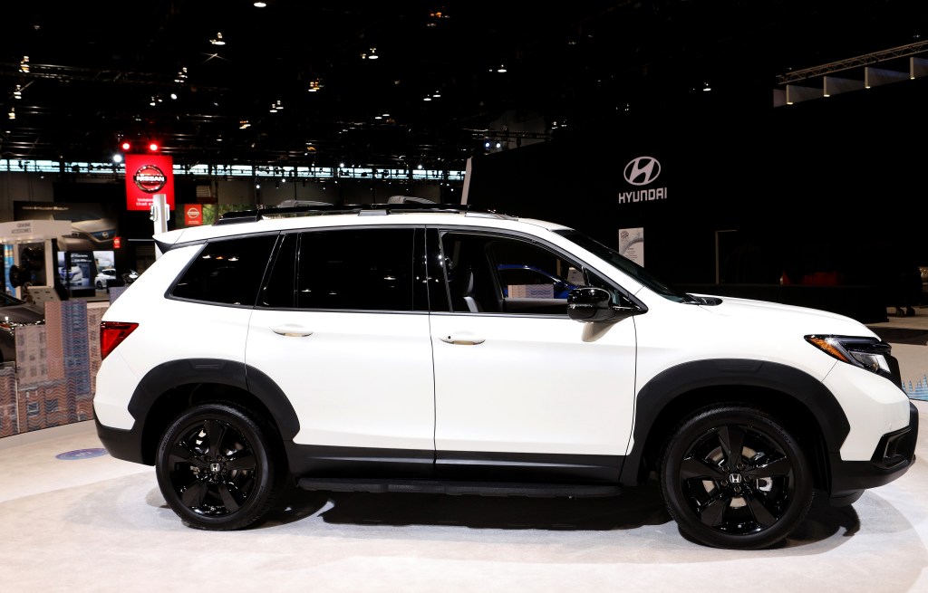 a white honda passport crossover SUV with black wheel on display at an auto show