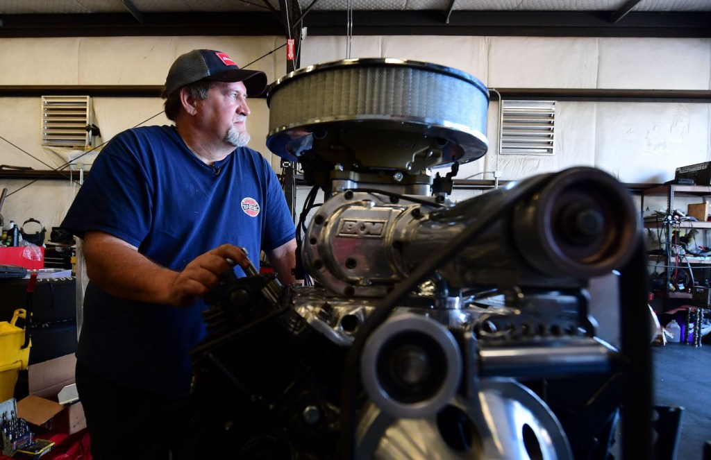 Keith Erwin, owner of Keith's Automotive in Fresno California beside his Chevy 350 engine, one of the best V8 truck engines.