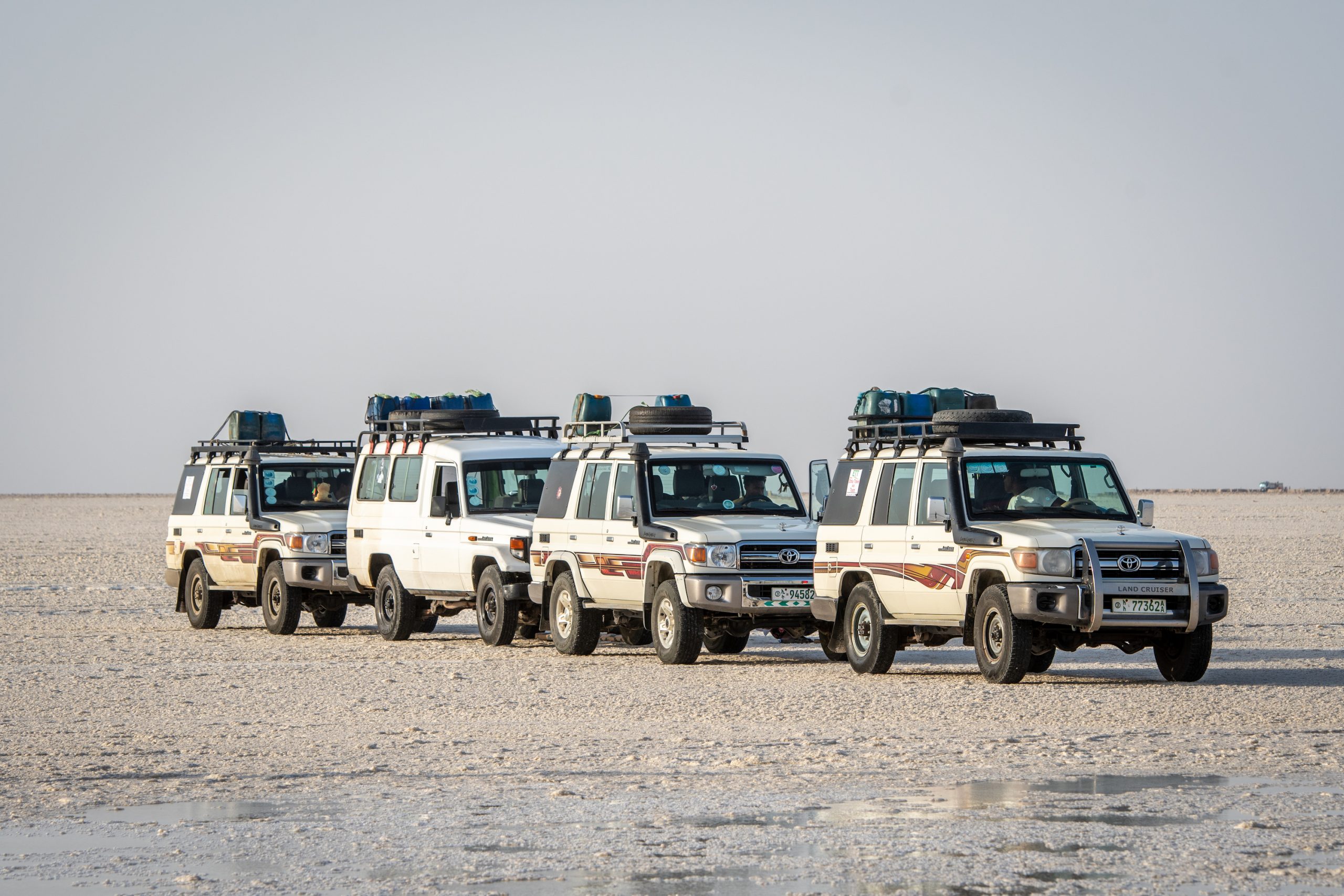 a troop of Land Cruiser J70 Toyota SUVs in that salt flats of Ethiopia.