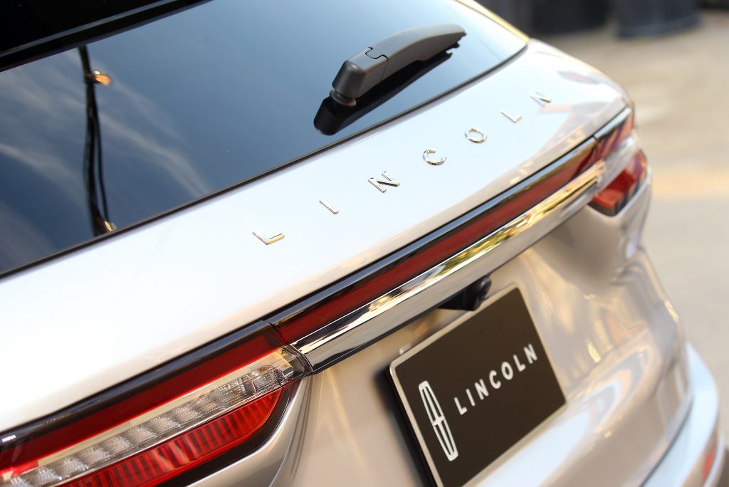 the rear of a white Lincoln Corsair with promotional LINCOLN license plate 