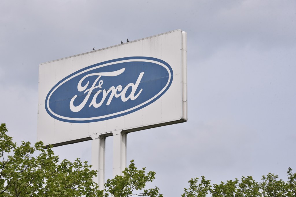 The Ford logo on a white sign outside a dealership