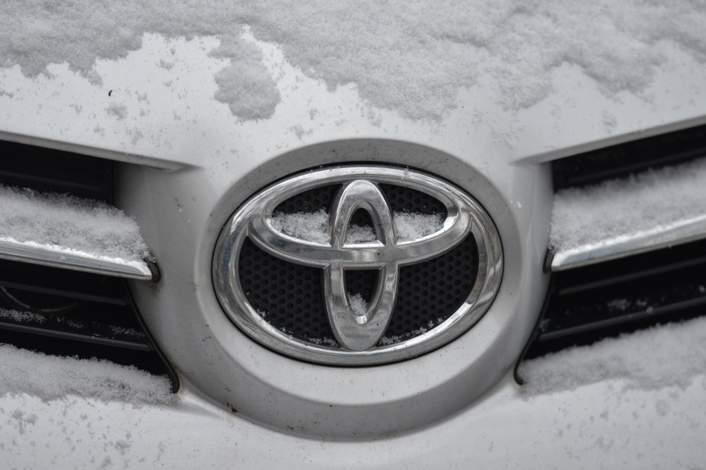 Toyota's logo on one of their vehicles, covered in fresh snow