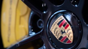 The wheel of a Porsche 911 featuring the legendary badge