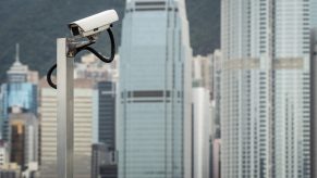 A surveillance camera outlined against a China city skyline