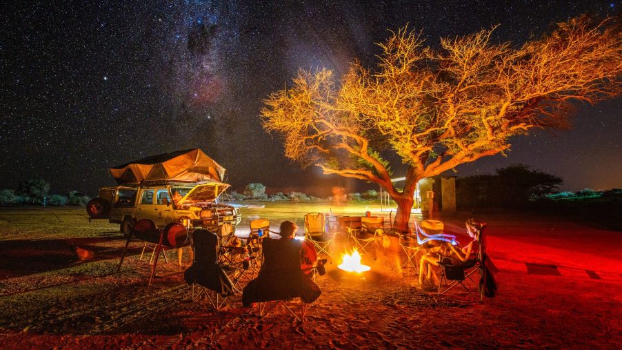 A group sits around a campfire under the milkway