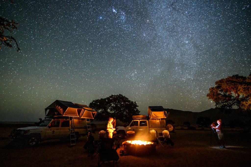 Overland Camping Shelter Options: A campsite set up under the wondrous night sky , Helmeringhausen, Namibia. (Photo by: Edwin Remsberg/VWPics/Universal Images Group via Getty Images)