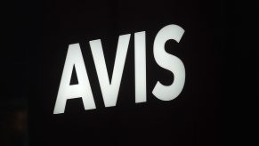 A white Avis logo over a black background