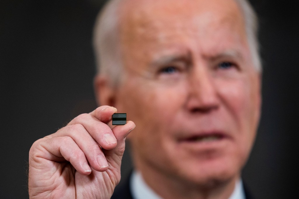 Biden holds a semiconductor during a news conference