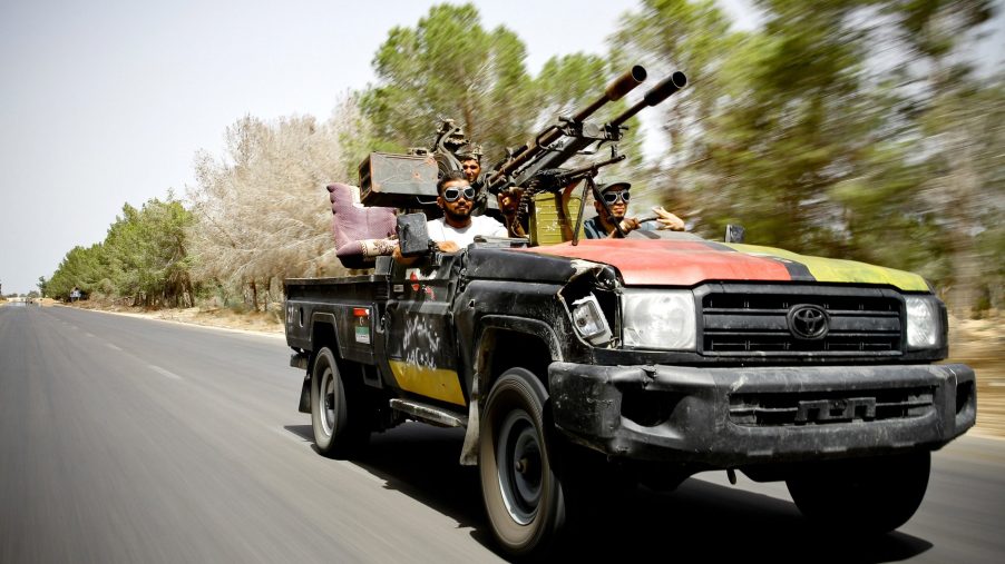 NTC fighters toting guns in a modified Toyota Land Cruiser in Libya