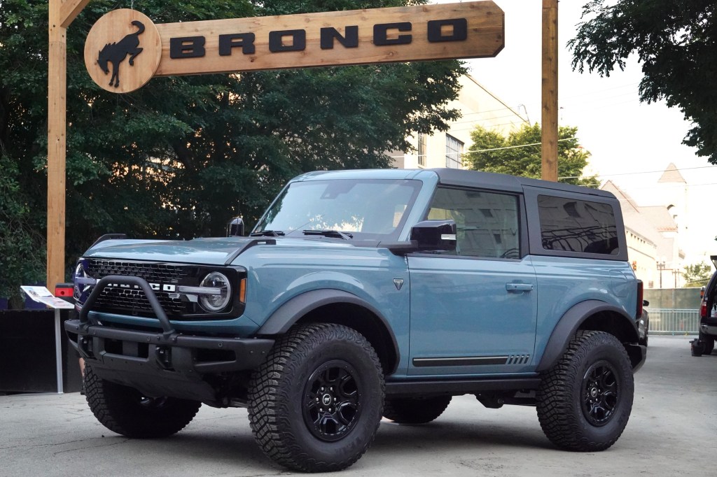 A 2022 Bronco sits under a banner bearing its name at the Chicago Auto Show