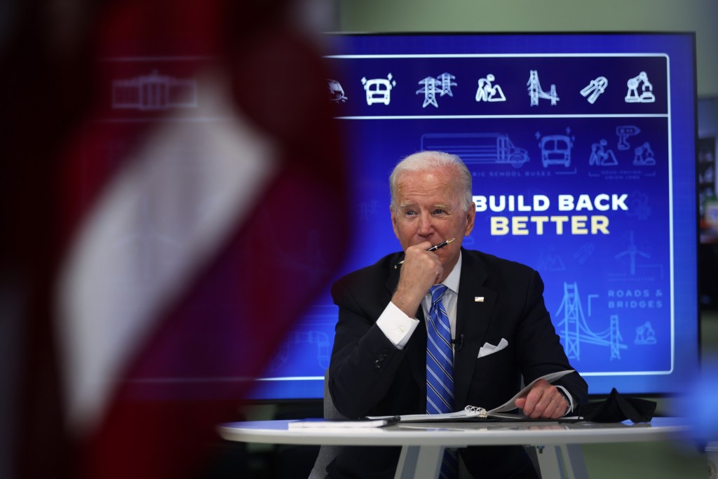 President Joe Biden sits at a table while promoting his infrastructure plans