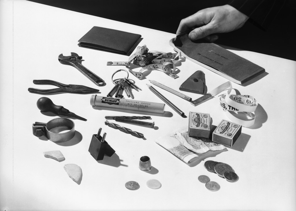 28th May 1954:  A collection of random objects, including a tape measure, a Dunlop pressure gauge, a thimble, and an assortment of tools, keys, buttons, money and matchboxes.  (Photo by Chaloner Woods/Getty Images). Some random items from our do it yourself car hacks.