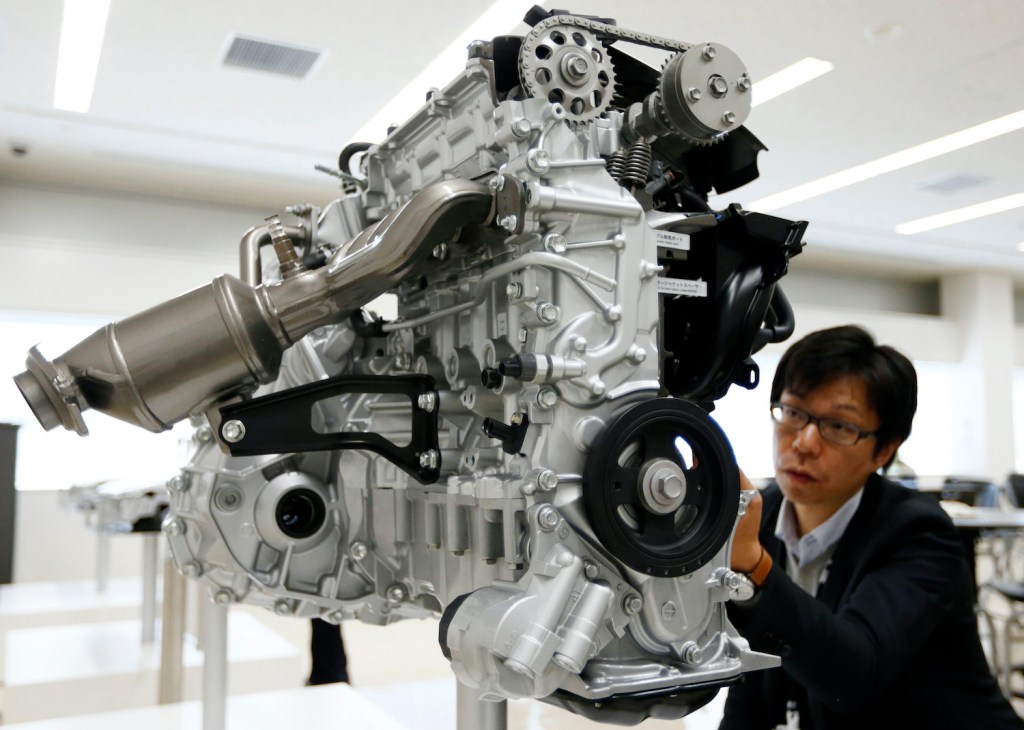 An employee looks at the engine for the Toyota Motor Corp. fourth-generation Prius hybrid vehicles ahead of a test drive at Fuji Speedway on November 12, 2015 in Oyama, Shizuoka prefecture, Japan. Tomohiro Ohsumi/Getty Images. Learn to decode your toyota engine name with our Toyota engine family chart and engine feature table.