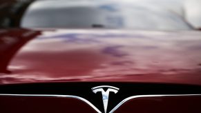 The badge of a Tesla Model S sedan in red
