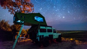 A rooftop tent on a land rover in Botswana. Find out the best rooftop tents for overland camping.