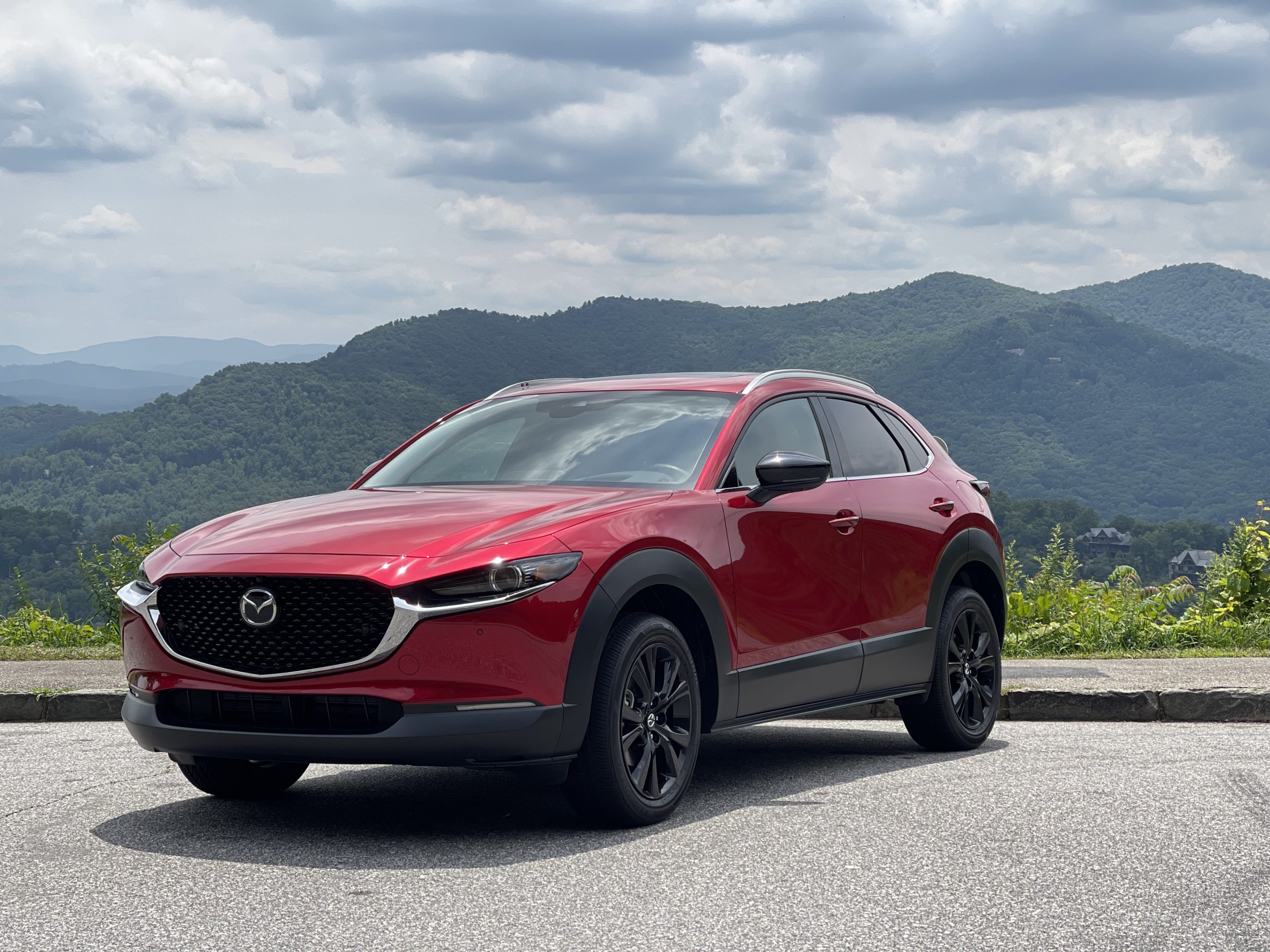 A red 2021 Mazda CX-30 turbo parked in front of a mountain view