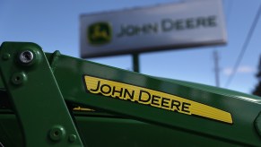 The John Deere logo on a tractor, John Deere makes some of the best zero-turn lawn mowers according to Consumer Reports