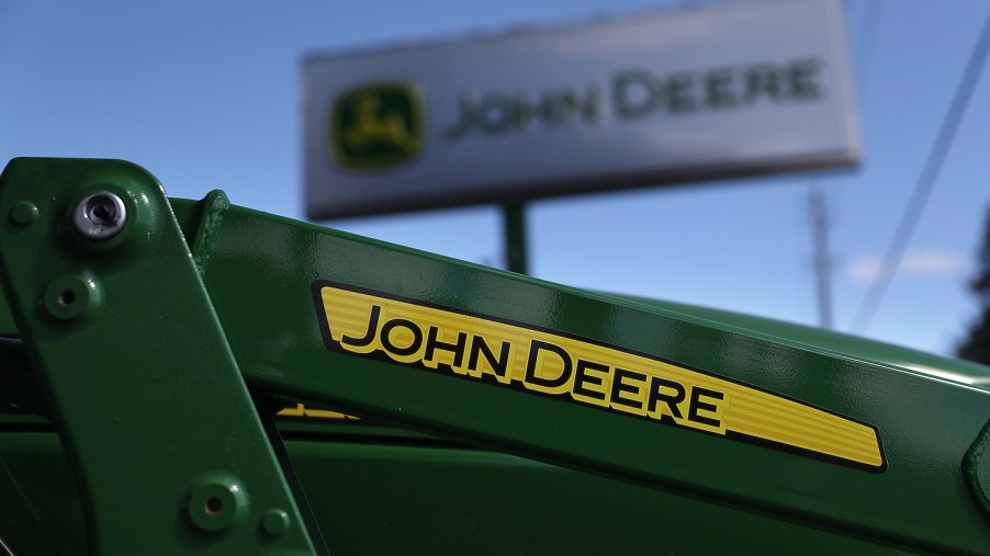 The John Deere logo on a tractor, John Deere makes some of the best zero-turn lawn mowers according to Consumer Reports