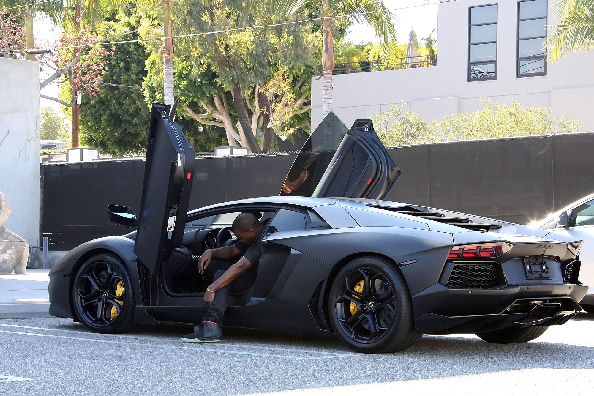 Kayne West exiting an exotic luxury car model in Los Angeles, California
