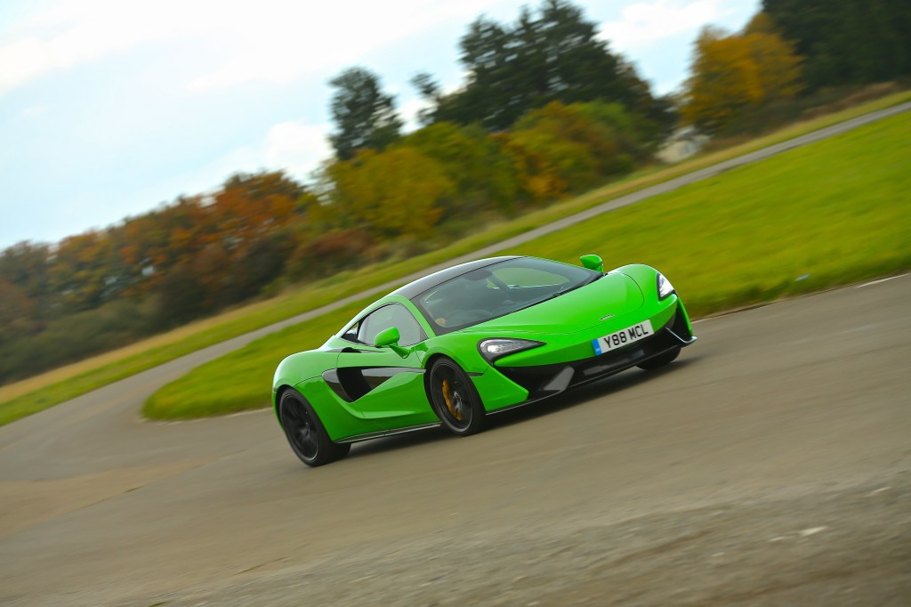 A green Mclaren 570s on a track in the UK