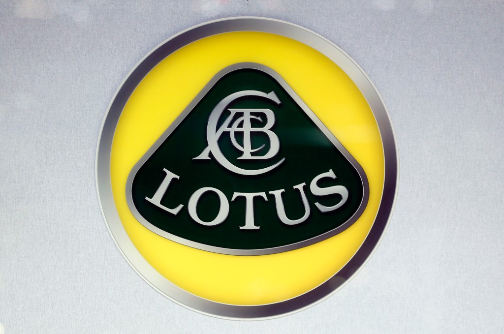 A yellow, black, and silver Lotus logo on display at the 2018 Paris Motor Show