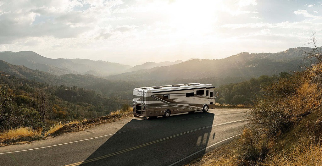 A Tiffin Phaeton diesel motorhome RV model driving on mountain roads.