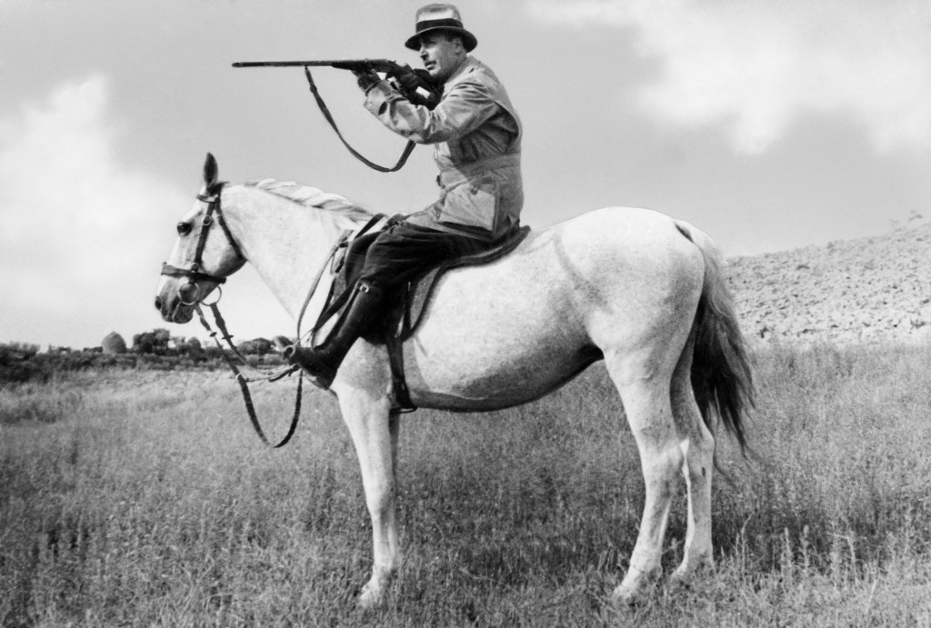 Man With Shotgun Riding A Horse