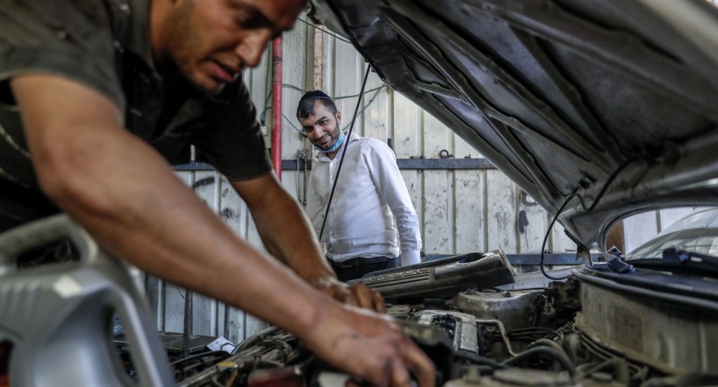 A man arrives to pick up his repaired car.