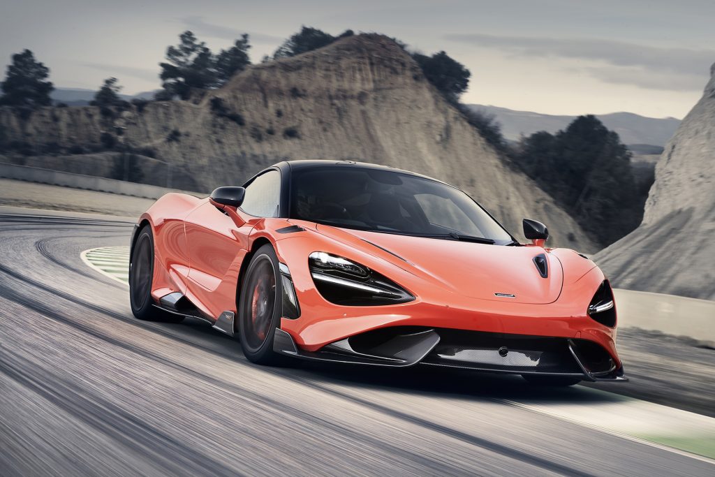 2021 McLaren 765LT supercar in orange driving on the road towards the camera is an example of what you can see at the Woodward dream cruise.