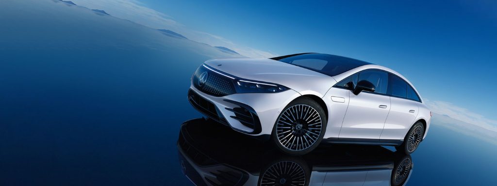 The 2022 Mercedes-Benz EQS model in white parked on a reflective surface