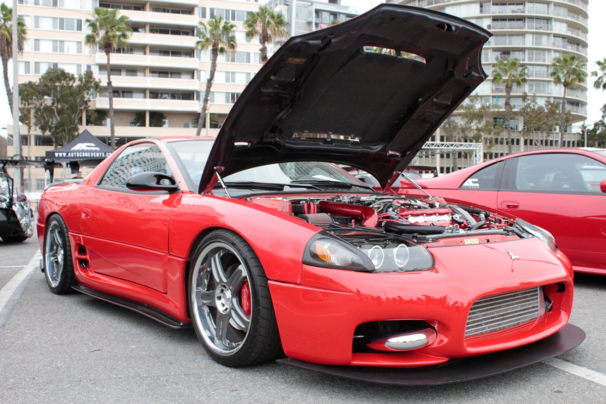 A red Mitsubishi 3000 GT VR-4 with its hood propped open.