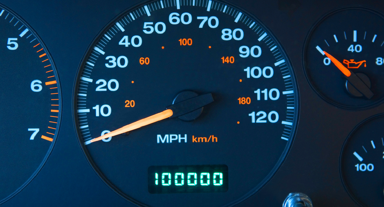 An automobile odometer with 100000 miles shown.