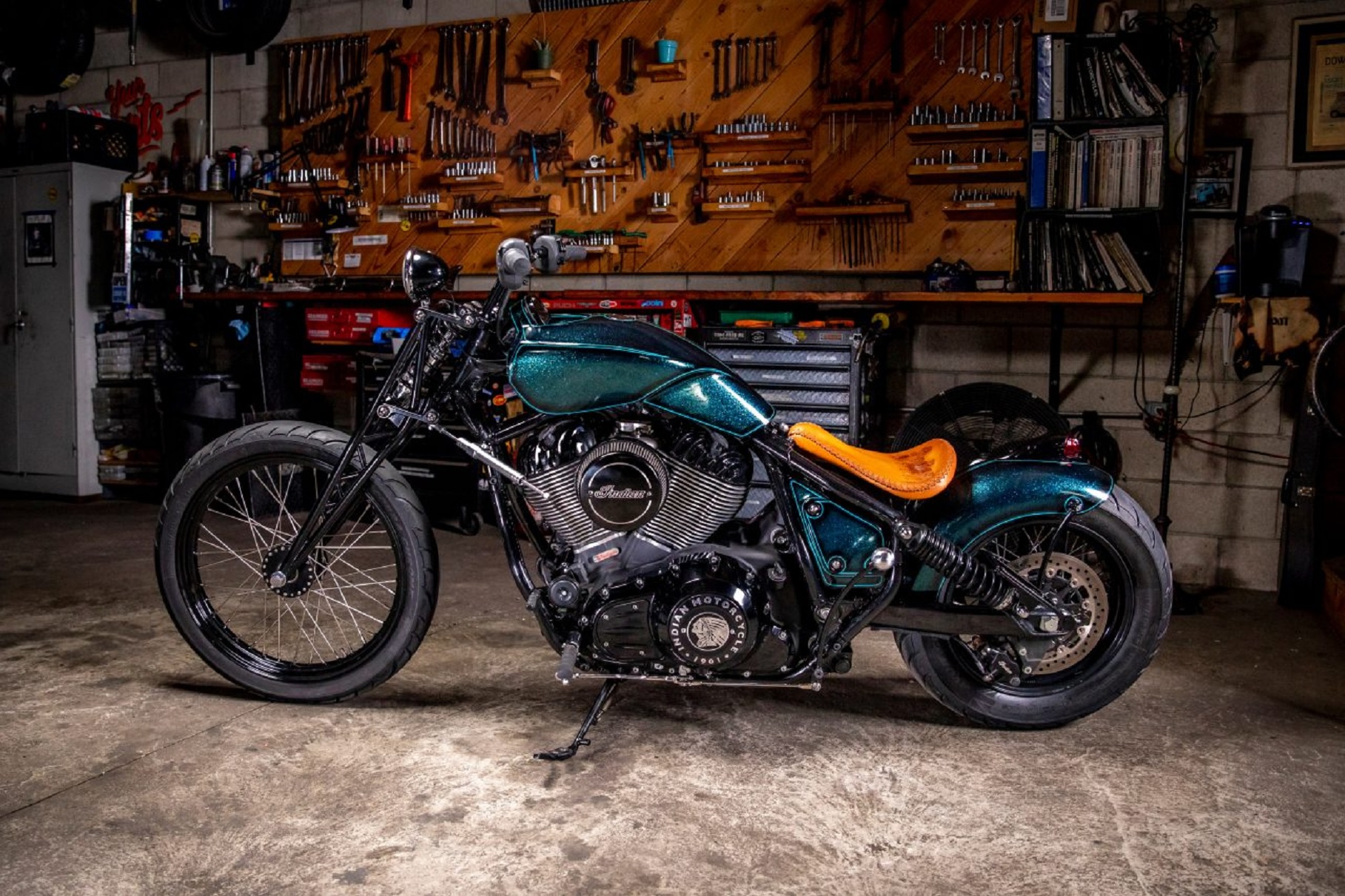 The side view of Paul Cox's and Keino Sasaki's metallic-green custom 2022 Indian Chief in a garage
