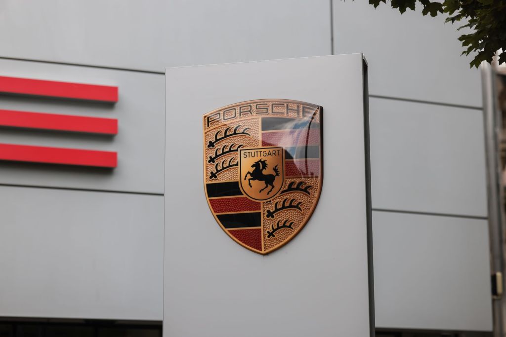 A Porsche sign in front of a building with the logo.