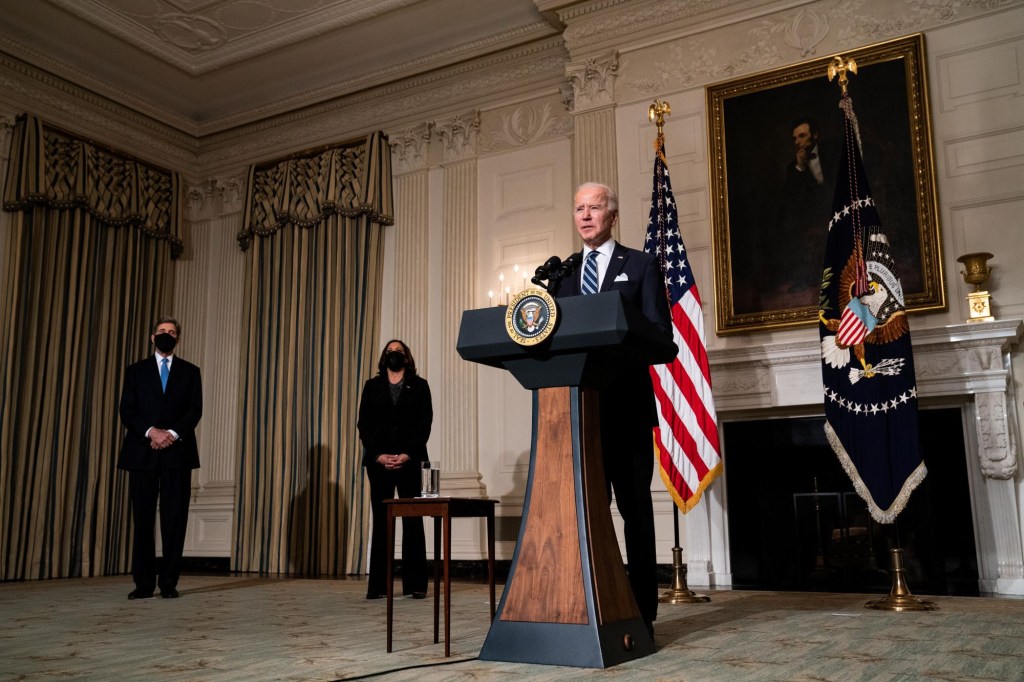 President Joe Biden speaking about climate change at the White House as John Kerry and Kamala Harris stand at his side