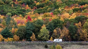 A pickup driving through VT with an RV camper attached