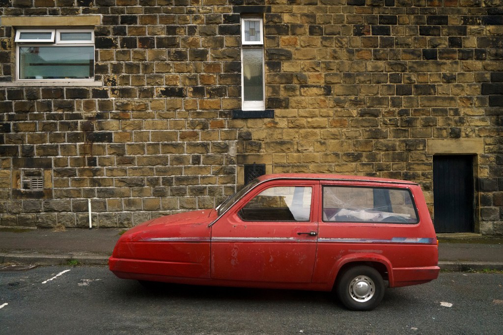 Reliant Robin parked on the side of the road in England. This little car is related to the Bond Bug used to create Luke Skywalker's Landspeeder