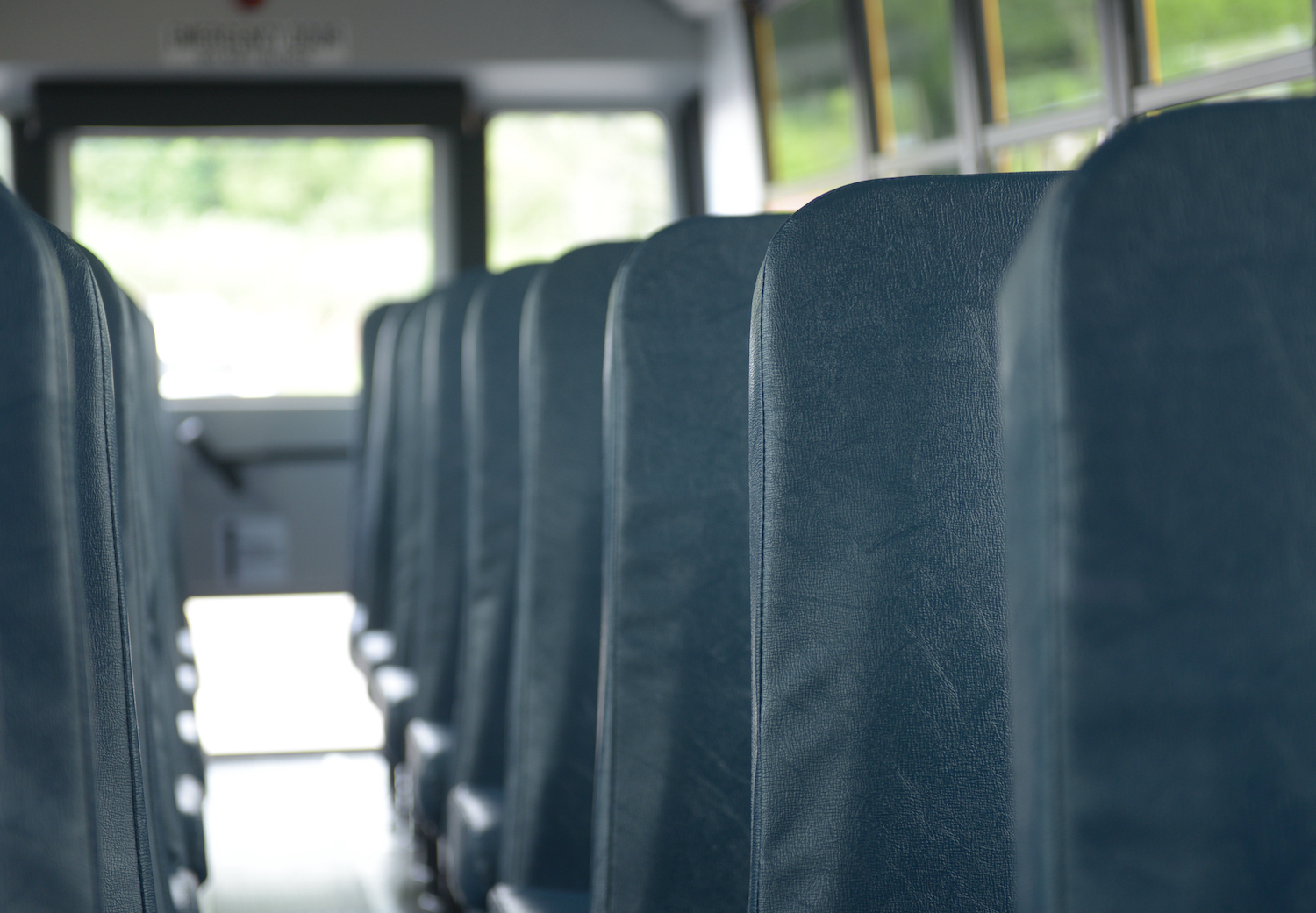 A lineup of school bus seats, most school buses don't have seat belts.