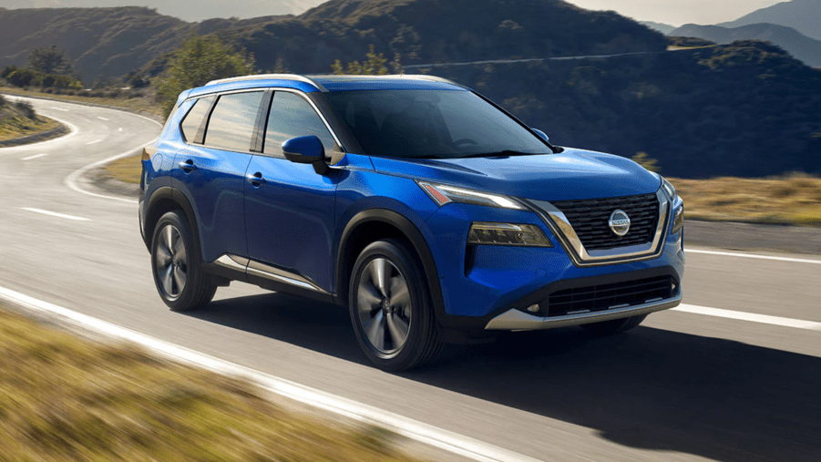 A blue 2021 Nissan Rogue driving on the road