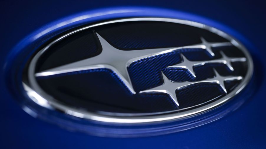 A dark blue Subaru logo with silver accents against a lighter blue background.
