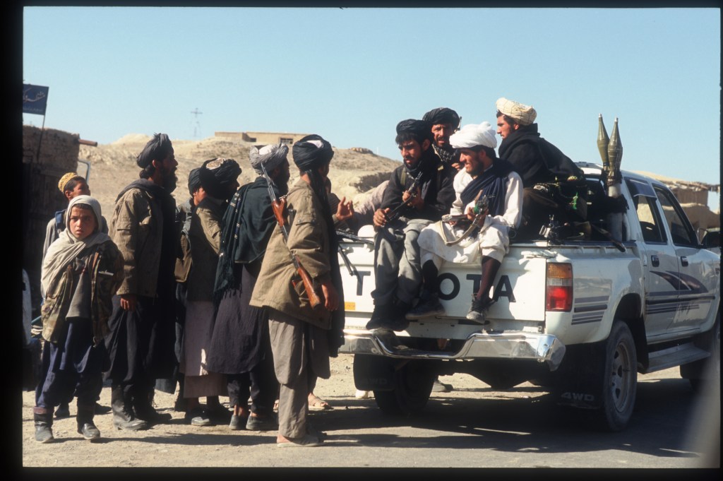 Taliban loaded into the back of an old Toyota pickup truck